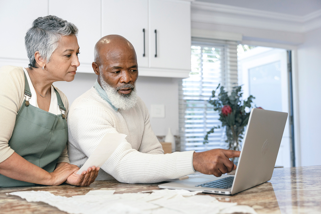Couple reviewing tax documents on laptop